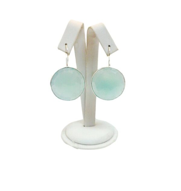 A pair of earrings on display in a white holder.