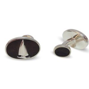 A pair of cufflinks with a sailboat on them.