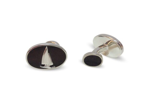 A pair of cufflinks with a sailboat on them.