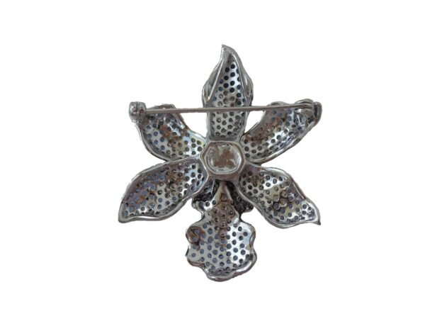 A silver Orchid Brooch - Sapphire with a textured, perforated design, isolated on a white background.