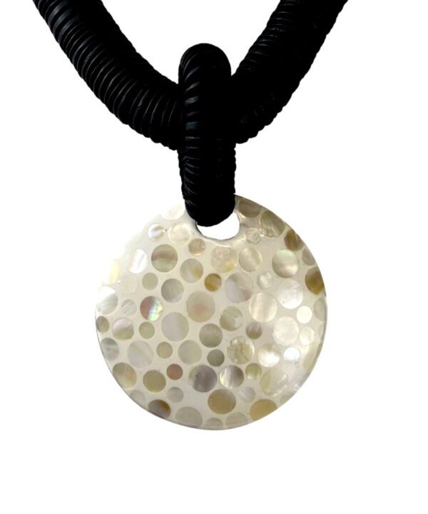 A necklace with a round shell pendant on a black cord.