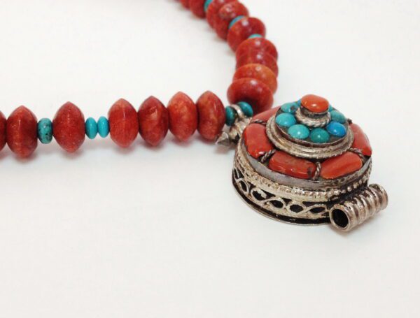 A necklace with red beads and turquoise stones.