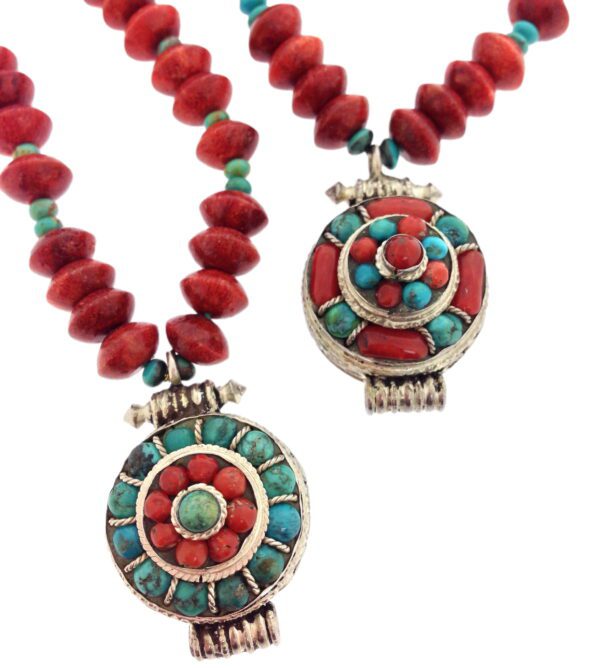 A close up of two necklaces with red and turquoise beads