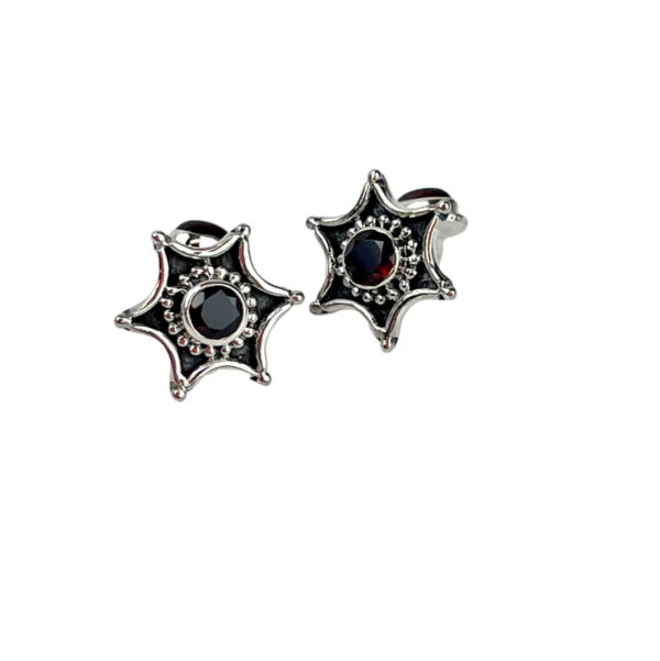 A pair of silver earrings with black and red stones.
