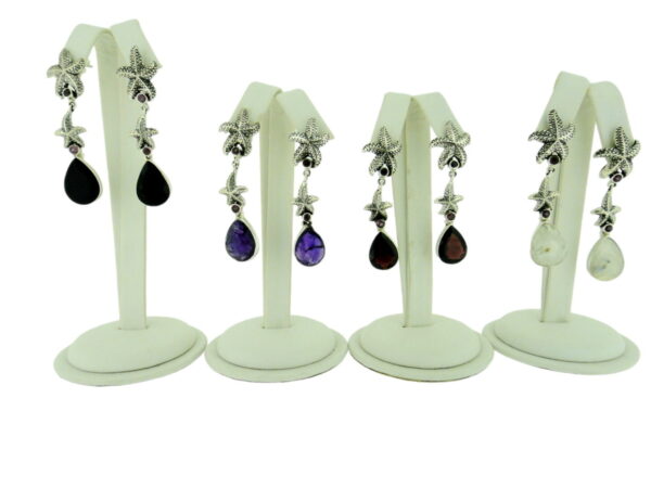 Four pairs of earrings are on display in a white case.