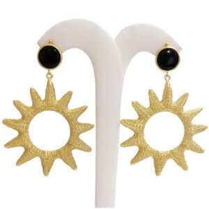 A pair of earrings with sun design and black stone.