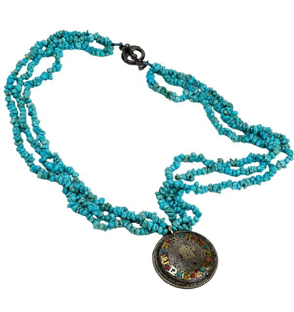 A necklace with turquoise beads and an oriental coin.