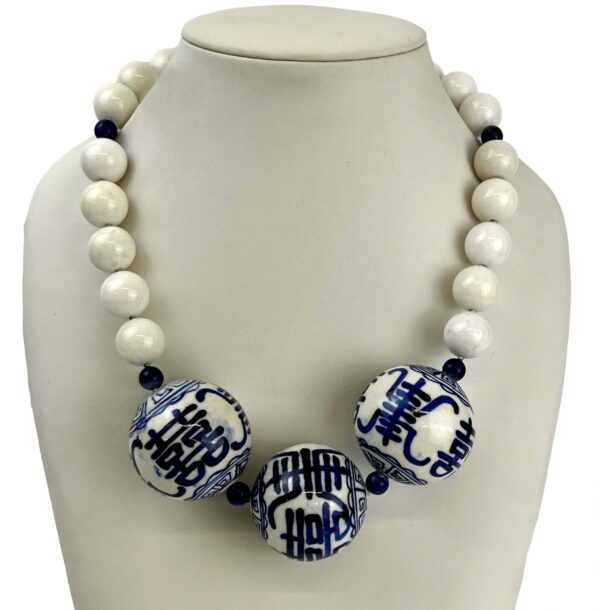 A White Onyx & Ceramic Accent Necklace with large white and blue patterned ceramic beads displayed on a white mannequin bust.