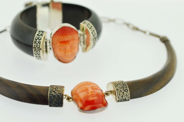 A bracelet and necklace with an orange face on it.