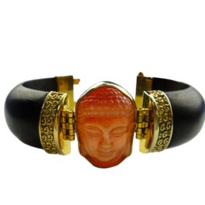 A bracelet with an orange buddha face on it.