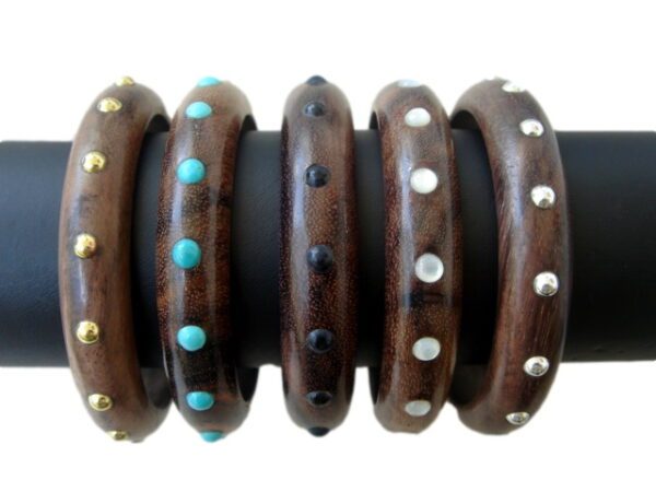 A group of wooden bracelets with different designs.