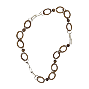 A brown and white necklace is shown on a green background.