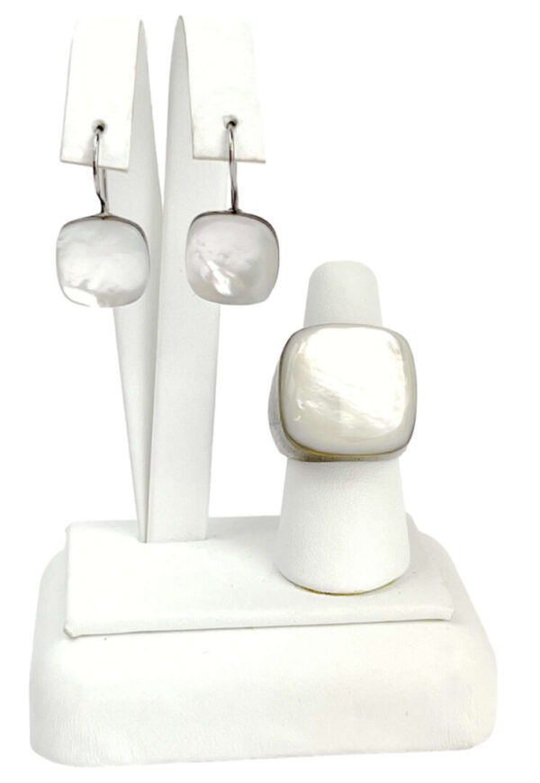 A white ring and earring set on display.