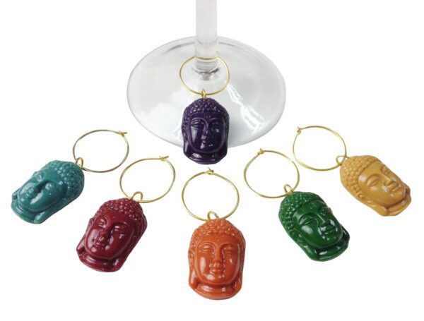 A set of six wine charms in the shape of buddha heads.