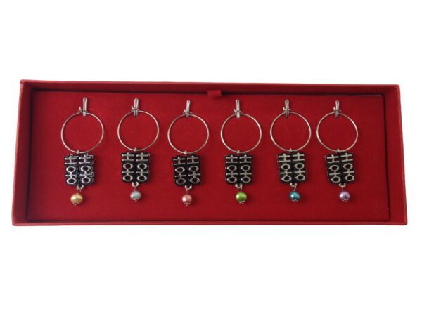 A set of six wine glass charms in a red box.