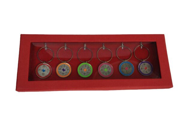 A red box with seven different colored glass discs hanging from it.