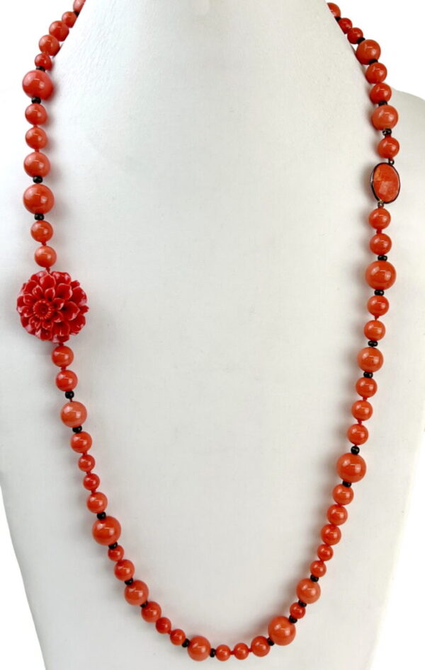 A red bead necklace with a flower on it.