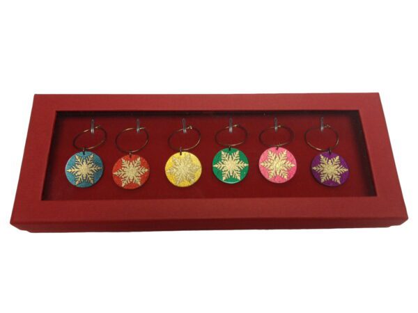 A red tray with six christmas ornaments in it.