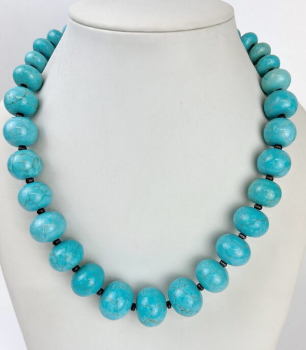 A necklace of turquoise beads is shown on display.