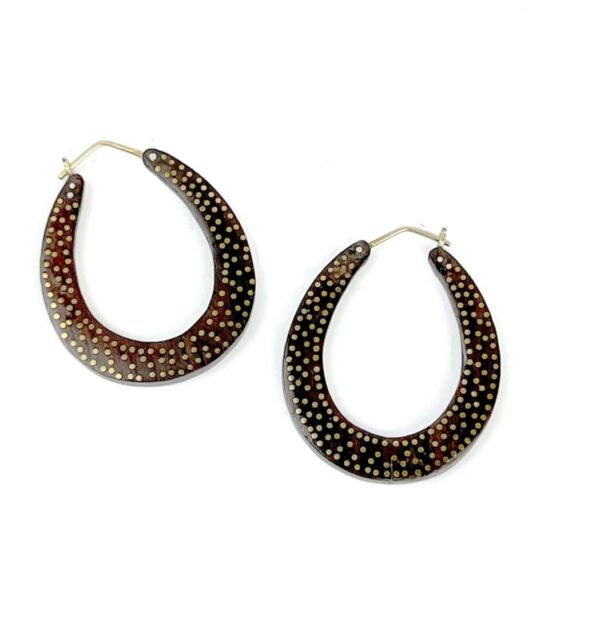 A pair of earrings with brown and black spots.