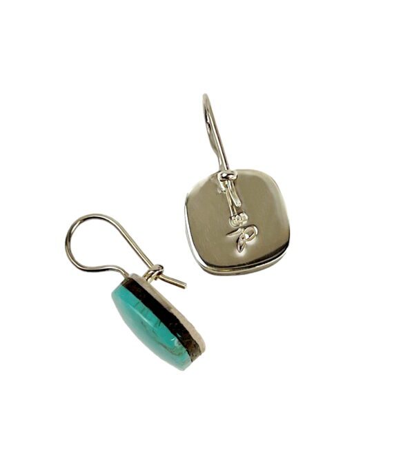 A pair of silver earrings with turquoise and an initial.