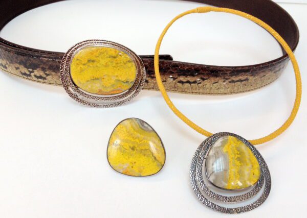 A yellow necklace and earrings set on top of a table.