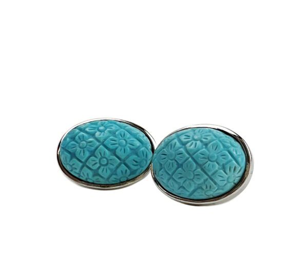 A pair of blue earrings with silver trim.