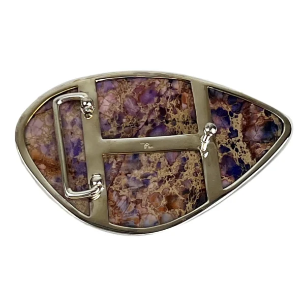 A belt buckle with purple and brown stones.