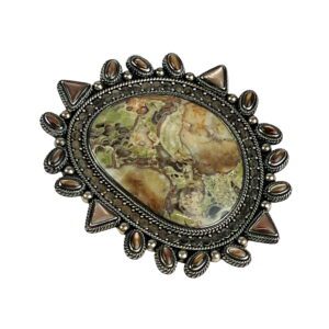 A picture of an ornate stone brooch.