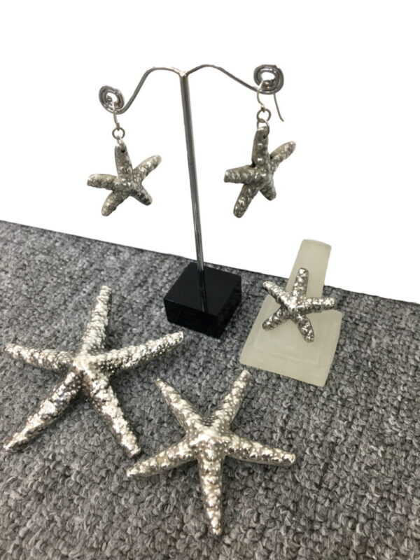 A pair of earrings and two pairs of rings are on the floor.