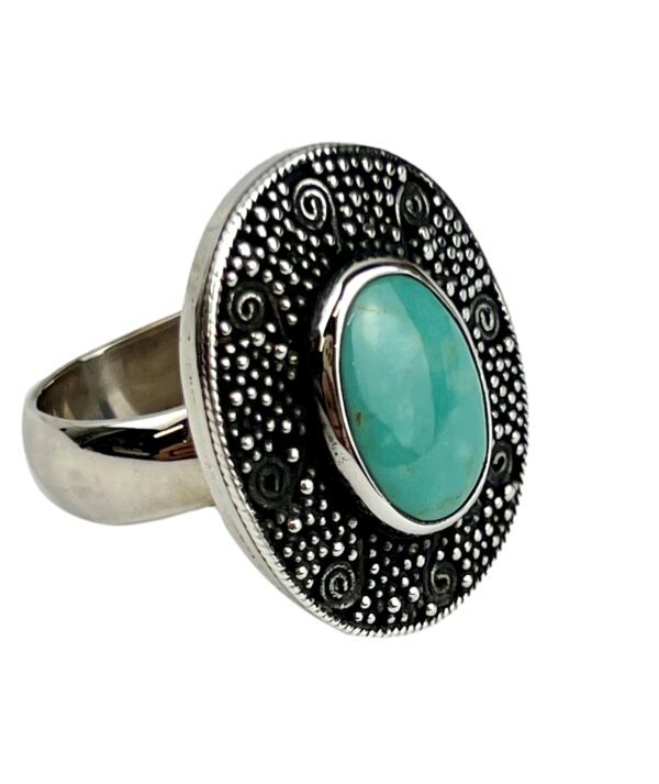 A silver ring with a turquoise stone on it.