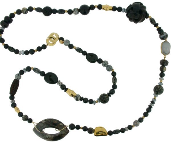 A long necklace with black beads and gold accents.